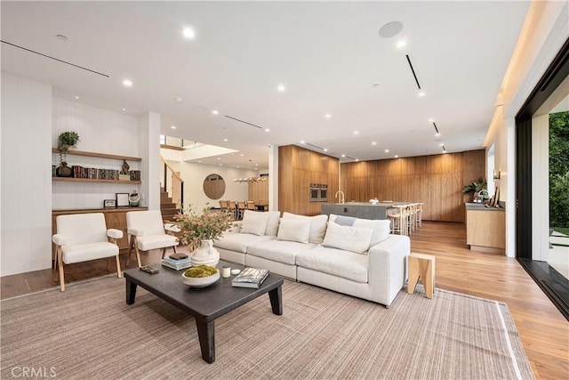 living room with wood walls and light wood-type flooring