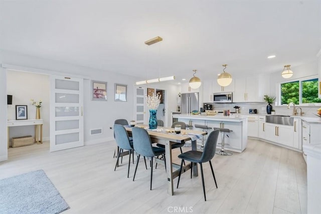 dining room with sink and light wood-type flooring