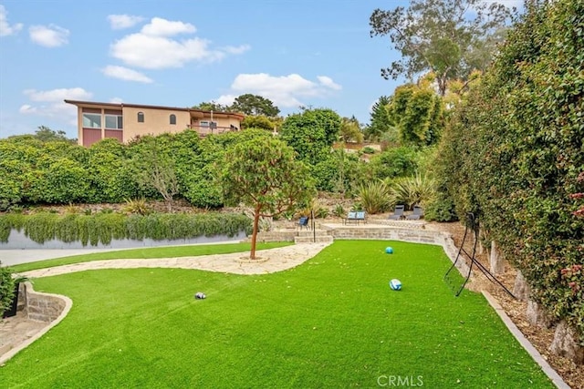 view of home's community with a water view and a yard