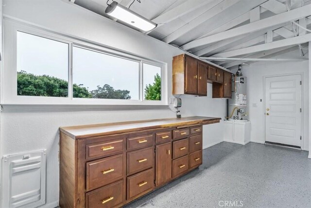 kitchen with dark brown cabinets, vaulted ceiling, and water heater