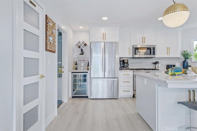 kitchen with decorative backsplash, stainless steel appliances, beverage cooler, and white cabinets