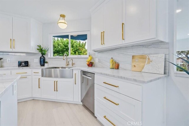 kitchen featuring white cabinetry, sink, backsplash, and stainless steel dishwasher