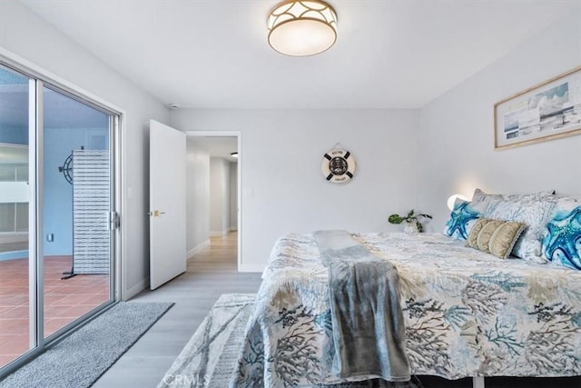 bedroom with access to exterior and wood-type flooring