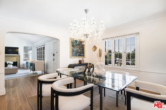 dining space featuring hardwood / wood-style floors, an inviting chandelier, and vaulted ceiling