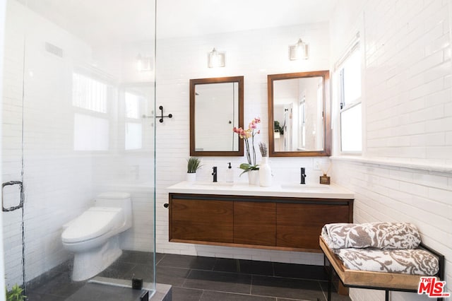 bathroom featuring an enclosed shower, vanity, tile walls, tile patterned flooring, and toilet