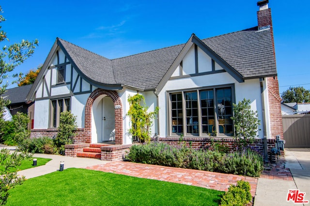 english style home with a front yard