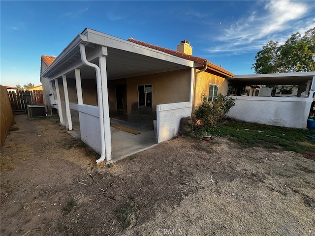 view of side of home with central AC