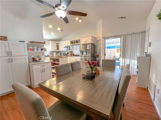 dining room featuring vaulted ceiling, light hardwood / wood-style flooring, and ceiling fan