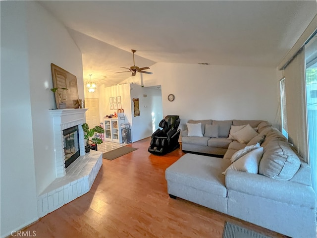 living room with lofted ceiling, ceiling fan, and wood-type flooring