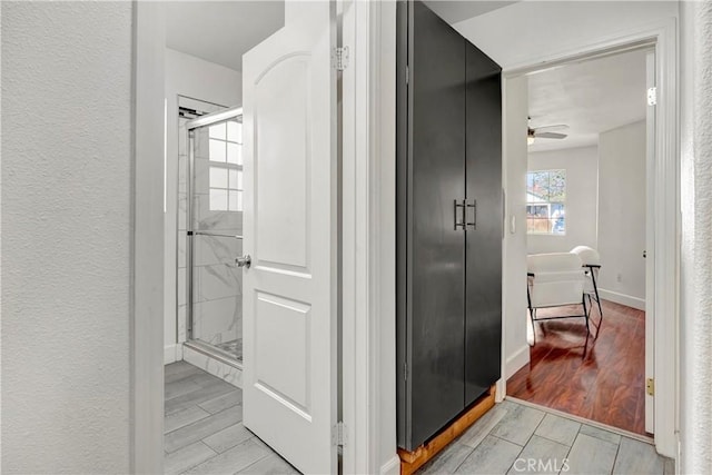 bathroom with ceiling fan and a shower with door