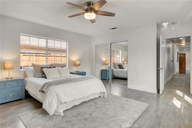 bedroom with light wood-type flooring, a closet, and ceiling fan