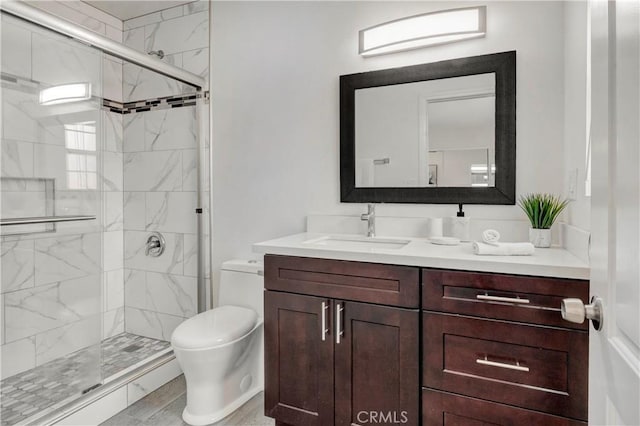 bathroom with an enclosed shower, vanity, and toilet