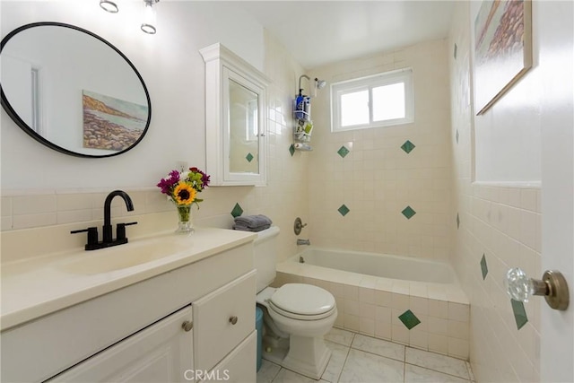 full bathroom with tiled shower / bath, tile patterned flooring, vanity, and toilet