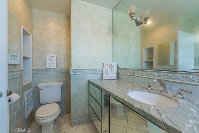 bathroom with toilet, sink, tile walls, and tile patterned flooring