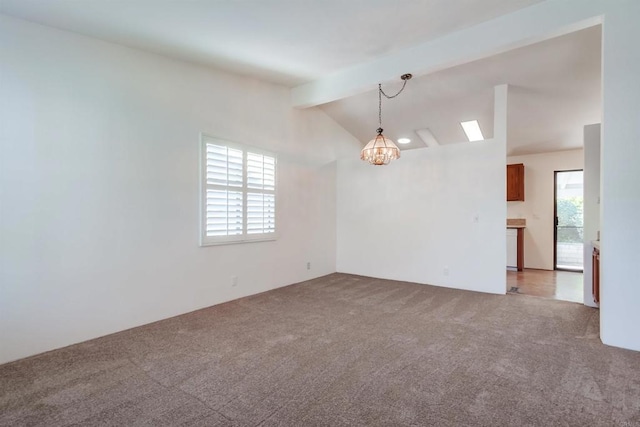 carpeted empty room with a chandelier and vaulted ceiling with beams