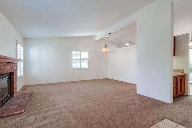 unfurnished living room featuring carpet floors, lofted ceiling with beams, a notable chandelier, and a fireplace