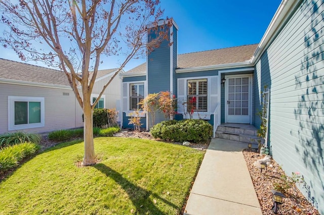 entrance to property with a lawn