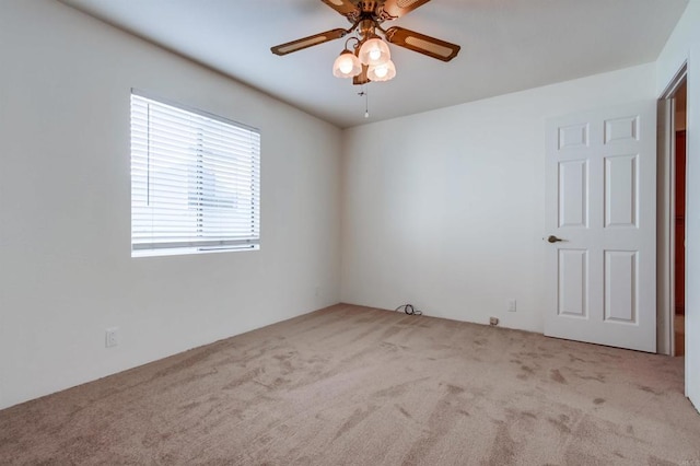 carpeted spare room with ceiling fan