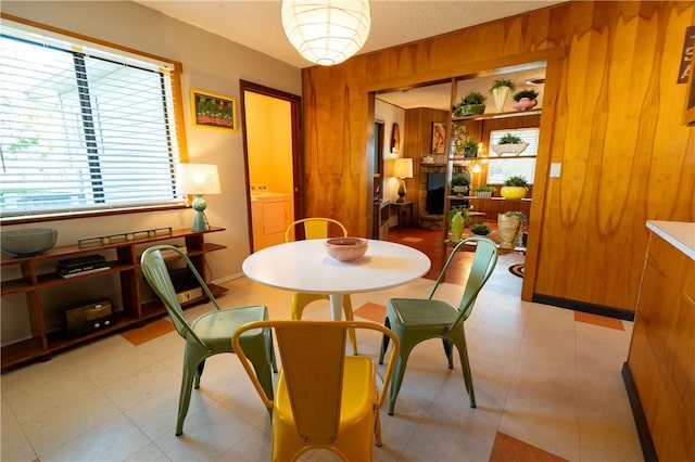 dining space with wooden walls and washer / dryer