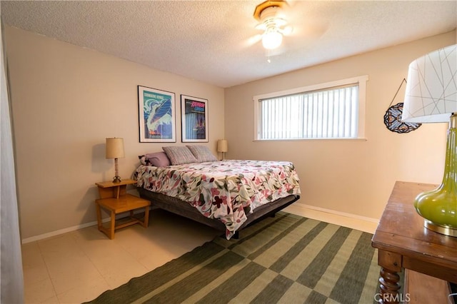 bedroom with ceiling fan and a textured ceiling