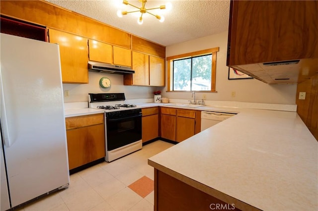 kitchen with a chandelier, a textured ceiling, white appliances, and sink