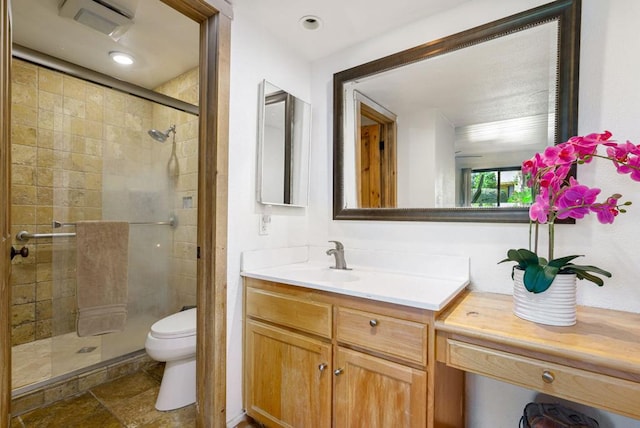 bathroom featuring vanity, toilet, and an enclosed shower