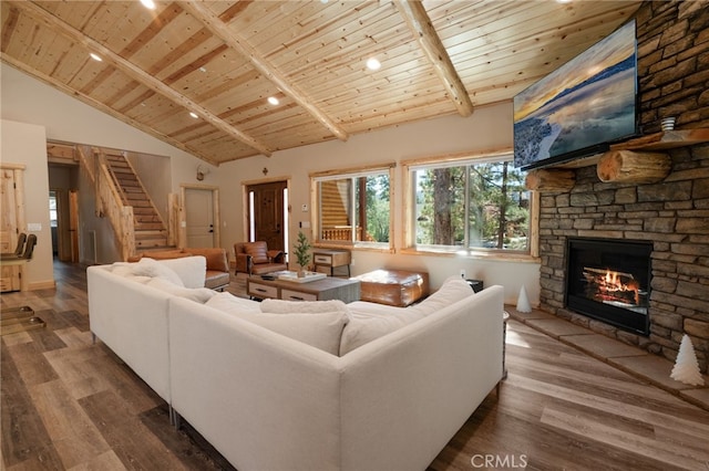 living room with wood ceiling, high vaulted ceiling, hardwood / wood-style flooring, and a stone fireplace