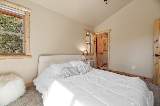 bedroom with vaulted ceiling, multiple windows, baseboards, and carpet floors