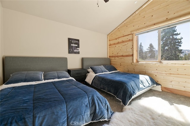 bedroom with wooden walls, ceiling fan, vaulted ceiling, and carpet