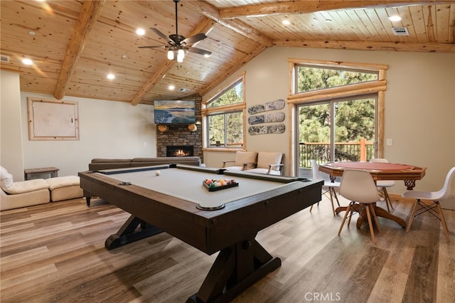 playroom featuring ceiling fan, vaulted ceiling with beams, light hardwood / wood-style flooring, wooden ceiling, and a fireplace