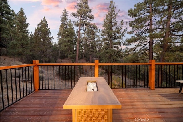 deck at dusk featuring an outdoor fire pit