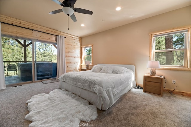 bedroom featuring access to exterior, multiple windows, ceiling fan, and light carpet