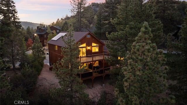 back house at dusk with a balcony