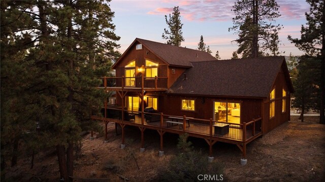 back house at dusk with a deck