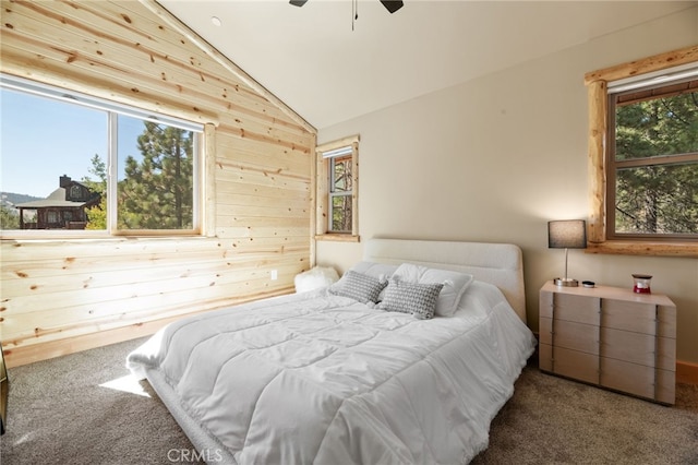 carpeted bedroom with ceiling fan, wooden walls, lofted ceiling, and multiple windows