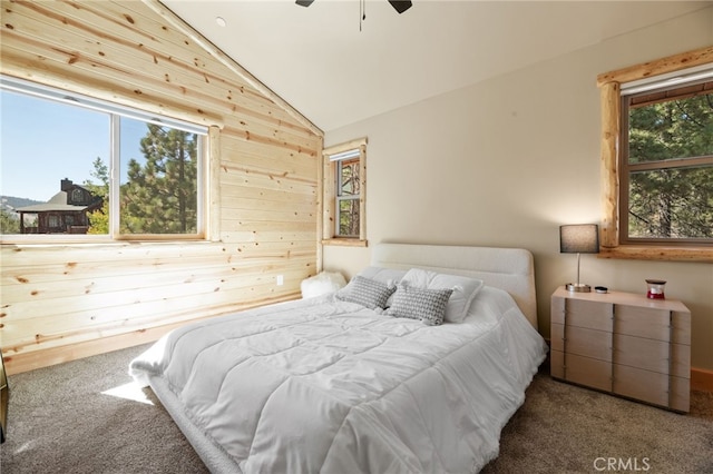 bedroom featuring ceiling fan, lofted ceiling, carpet, and wood walls