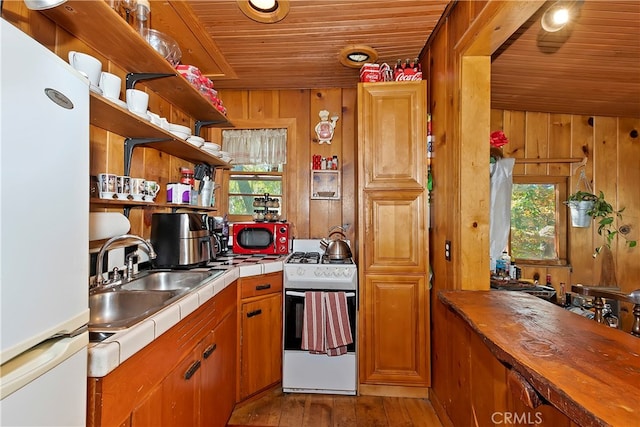 kitchen featuring light hardwood / wood-style flooring, wooden walls, white appliances, and wooden ceiling