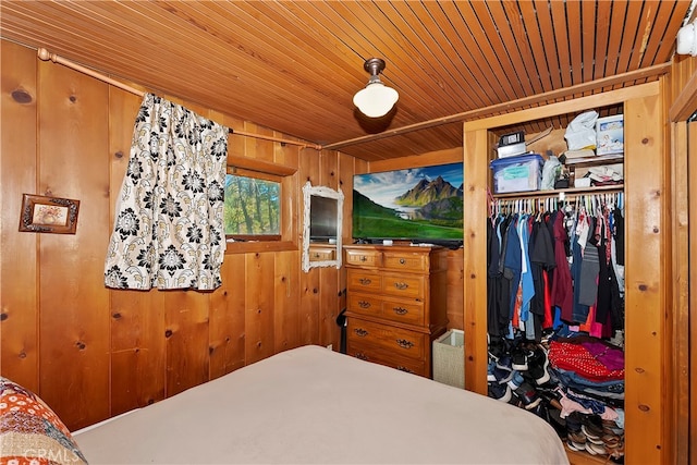 bedroom featuring a closet, wooden ceiling, and wooden walls