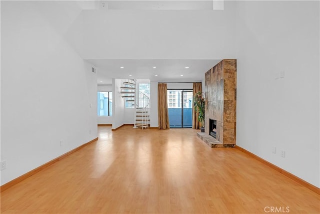 unfurnished living room with a large fireplace and light hardwood / wood-style flooring