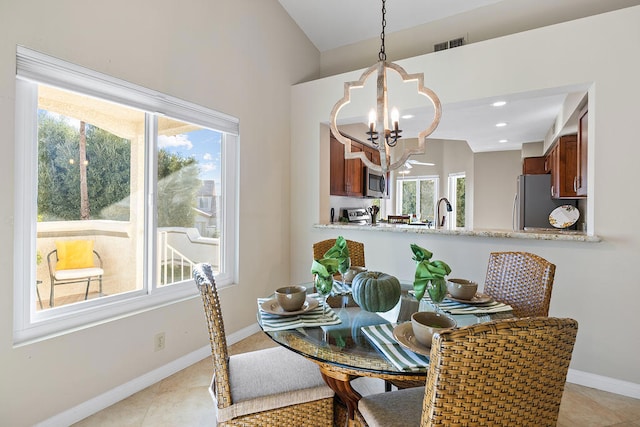 dining area featuring a chandelier, light tile patterned floors, plenty of natural light, and sink