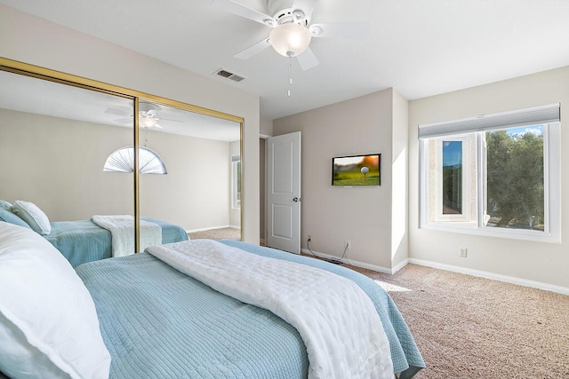 carpeted bedroom with ceiling fan and a closet