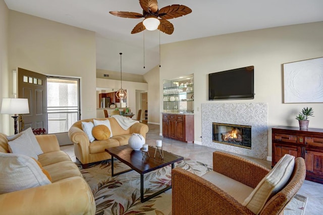 living room with a fireplace, high vaulted ceiling, and ceiling fan