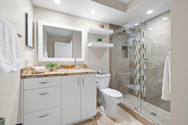 bathroom with walk in shower, vanity, and toilet