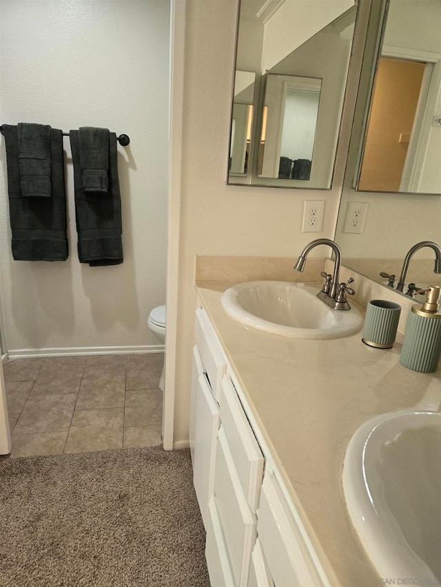 bathroom with tile patterned flooring, vanity, and toilet