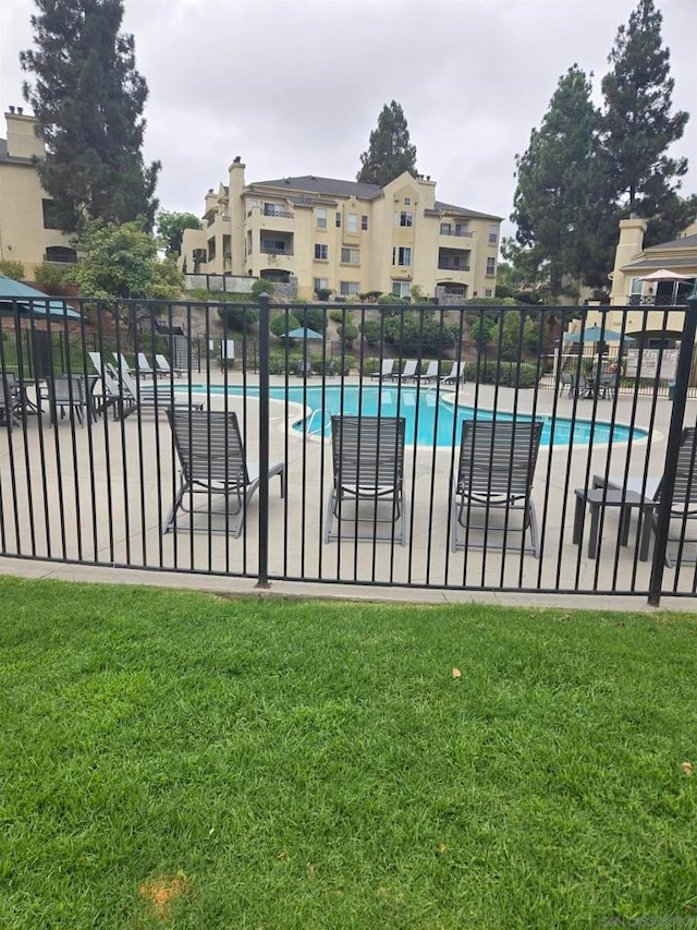 view of pool with a lawn