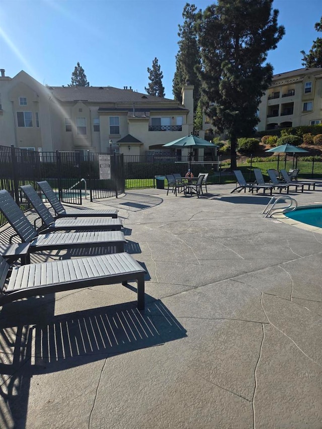 view of property's community with a pool and a patio