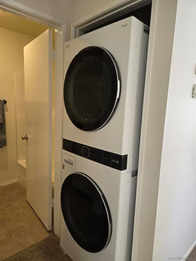 washroom featuring light tile patterned flooring and stacked washer and dryer