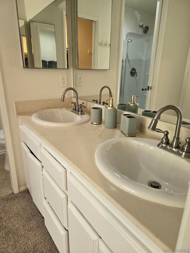 bathroom with vanity, toilet, and a shower with door