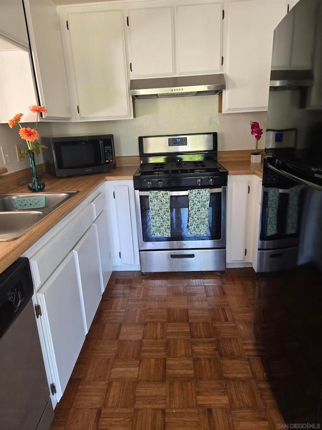 kitchen featuring white cabinets, appliances with stainless steel finishes, sink, and dark parquet floors