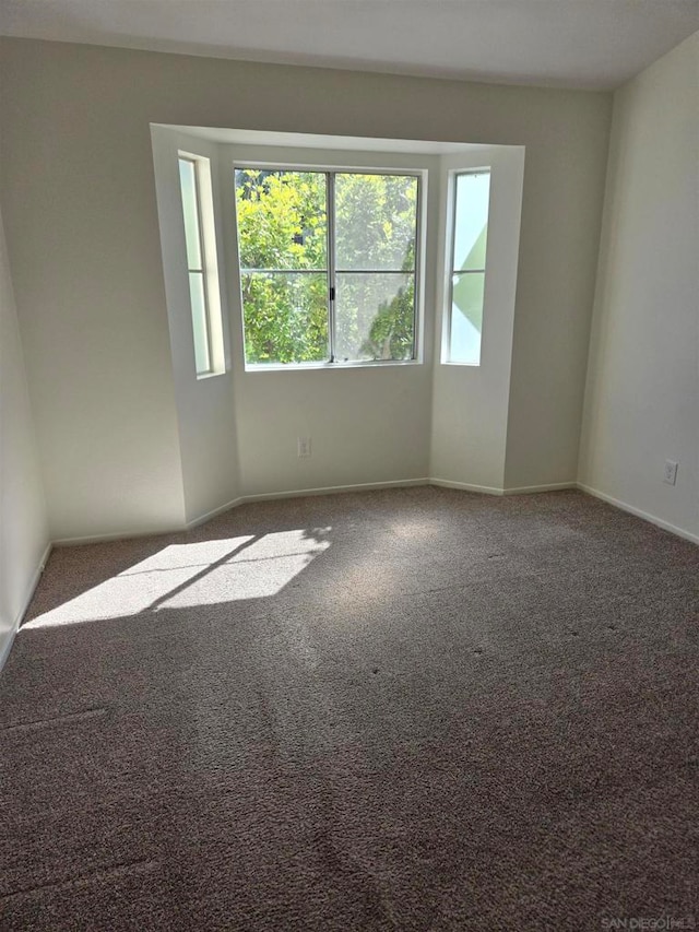 spare room featuring dark carpet